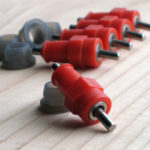 Five stainless steel push-in poultry nipples with red casing and silicone grommets