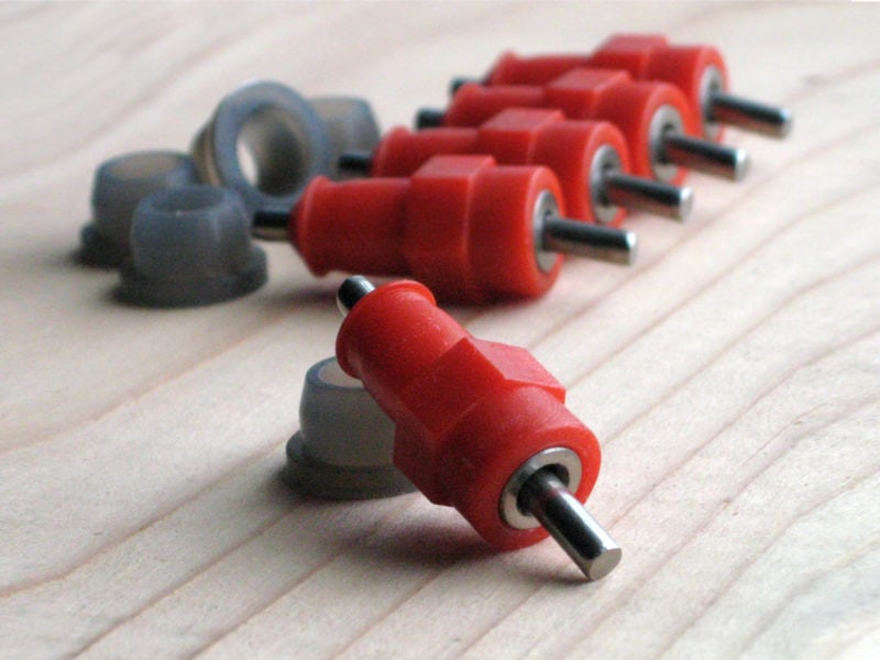 Five stainless steel push-in poultry nipples with red casing and silicone grommets